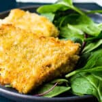 panko crusted rockfish on a plate with spinach.