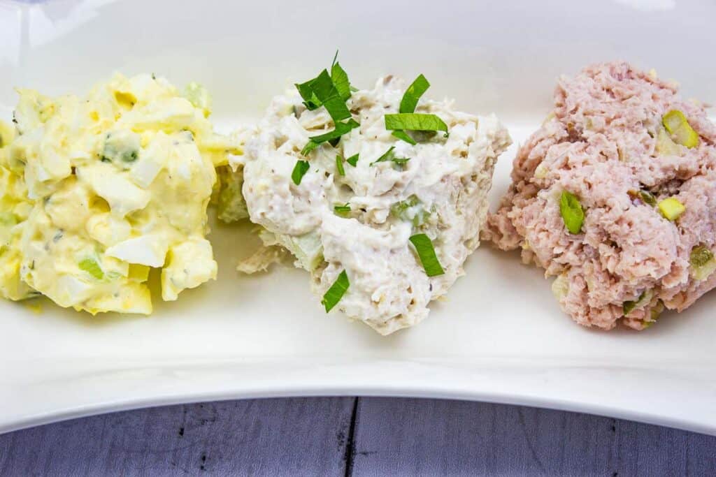 Ham salad, egg salad, and chicken salad on a plate.