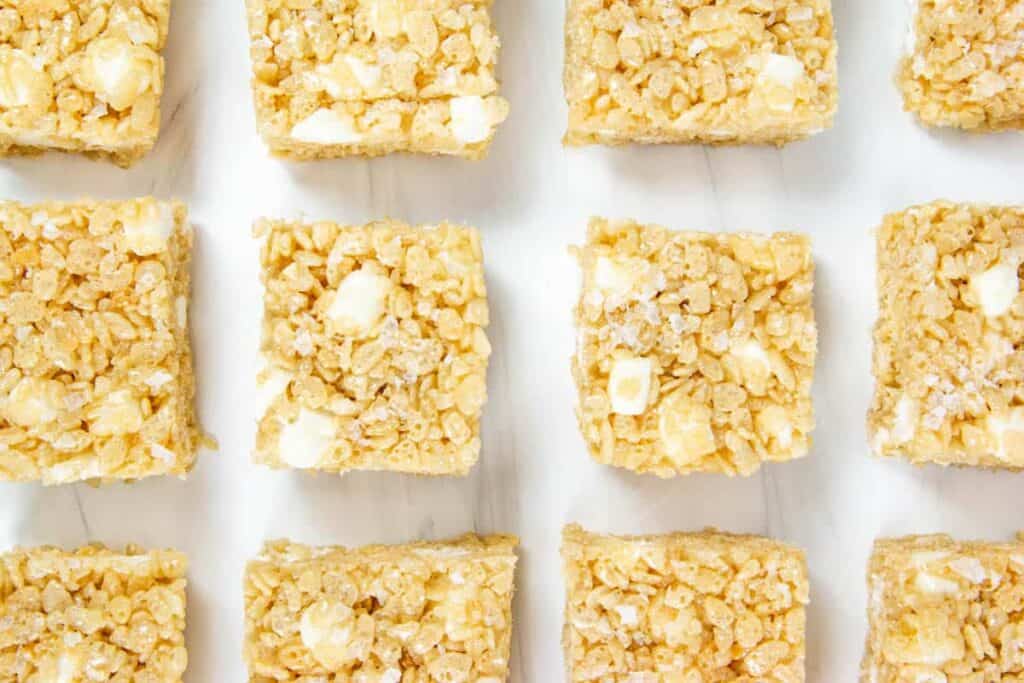 a grid of Salted Brown Butter Bourbon Rice Krispie Treats on a marble background