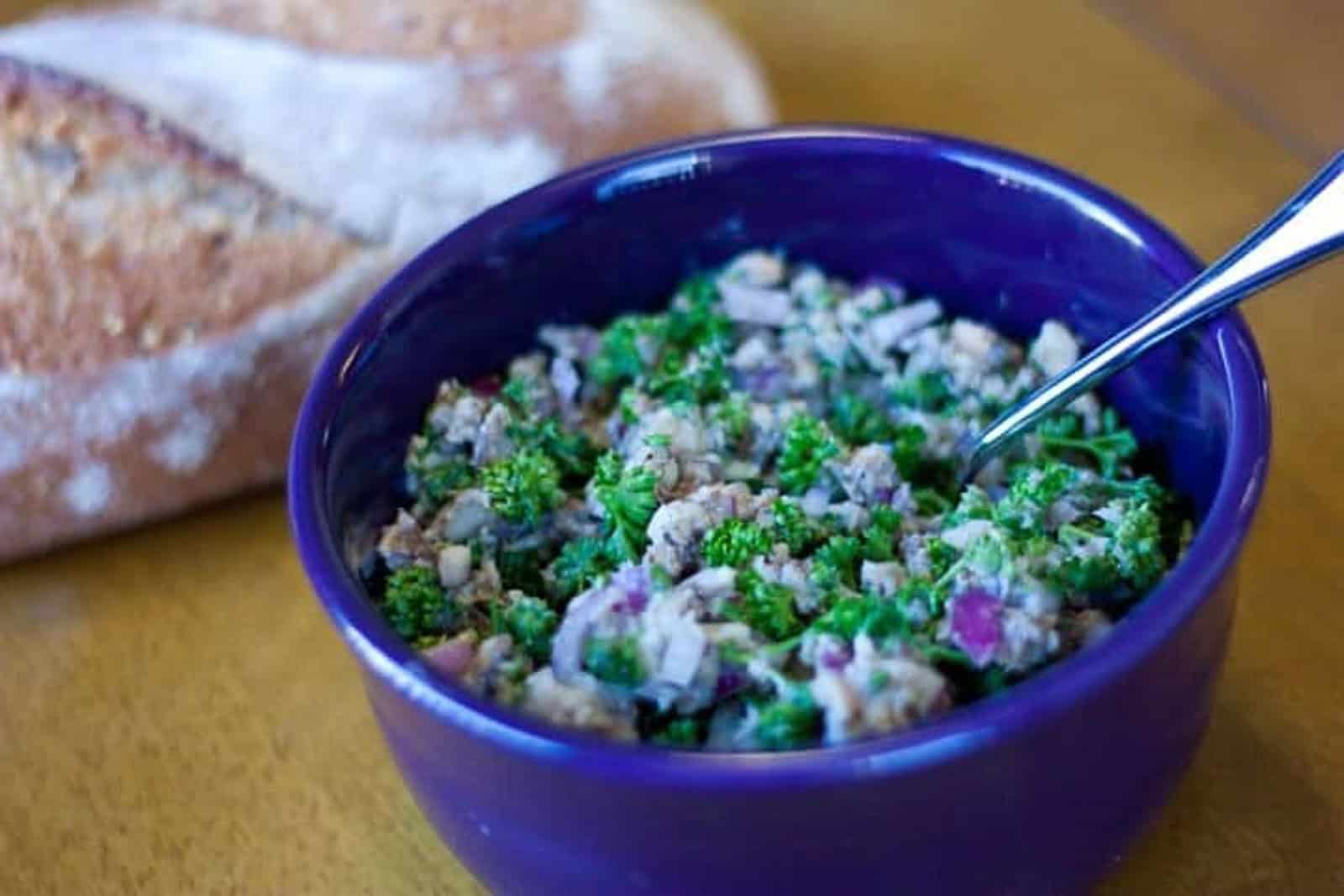 Sardine salad in a blue bowl with bread on the side.