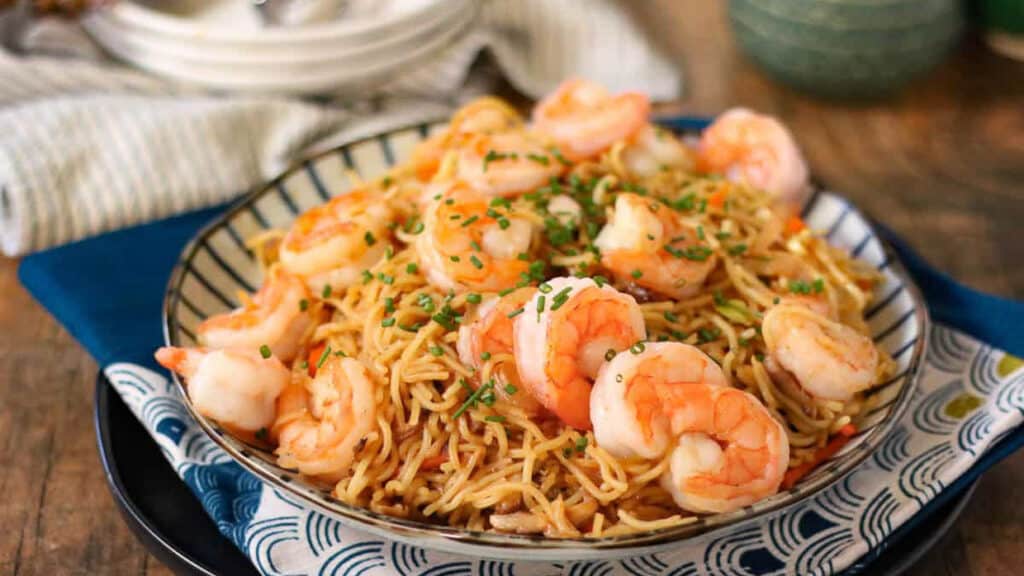 Shrimp yakisoba on a striped plate.