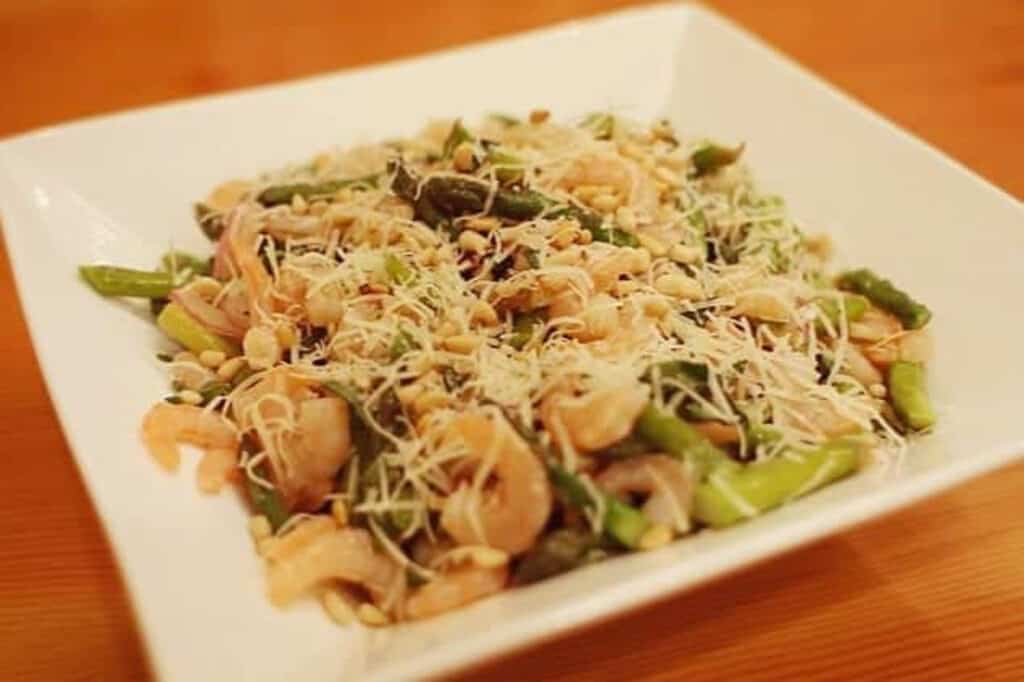 Asparagus and shrimp salad in a white bowl.