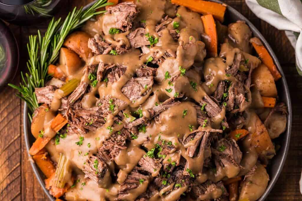 A bowl of pot roast with red wine.
