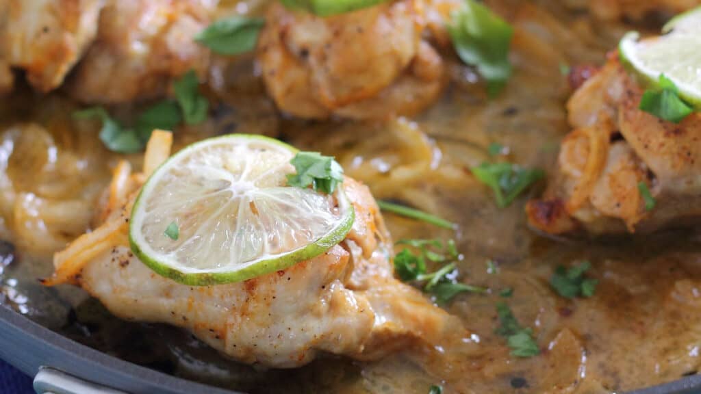 Sriracha lime chicken thighs in a skillet.