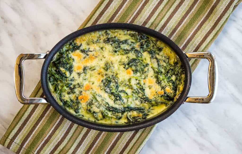 Steakhouse Creamed Spinach in a black dish on a cloth.