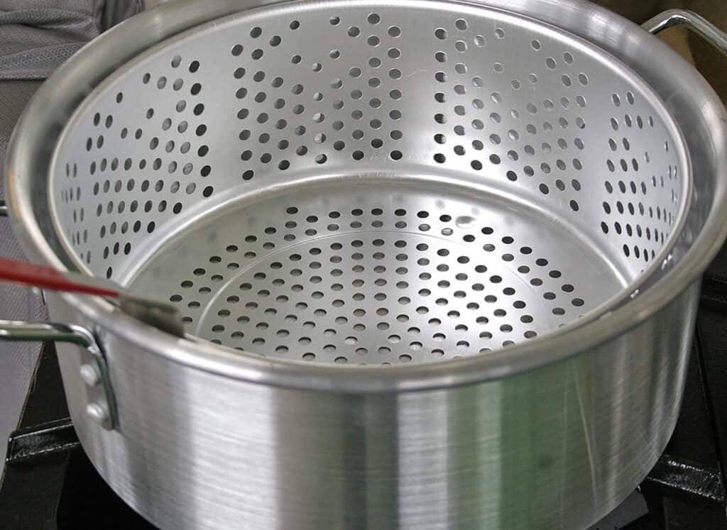 Metal strainer in stainless steel pot.