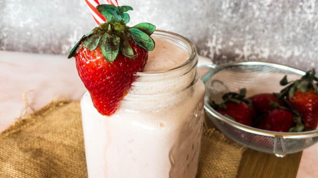 easy strawberry smoothie no banana with fresh strawberry on rim