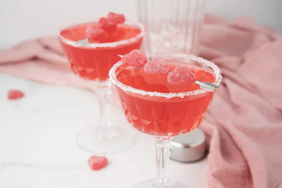 A strawberry cocktail with sour candy garnish.