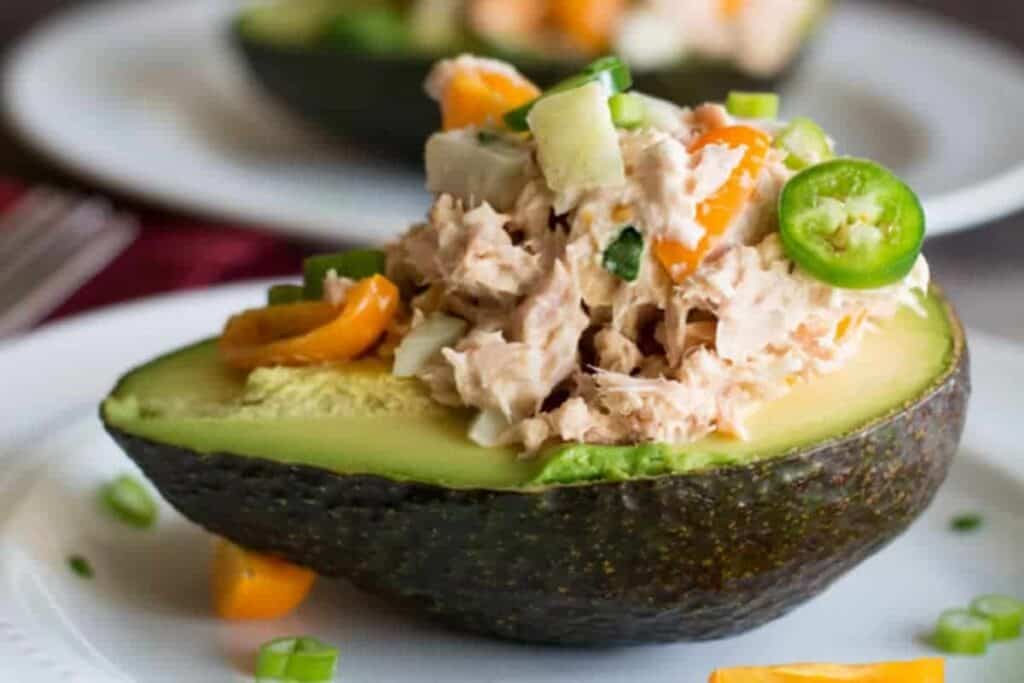 Tuna Salad Stuffed Avocado on white plates.