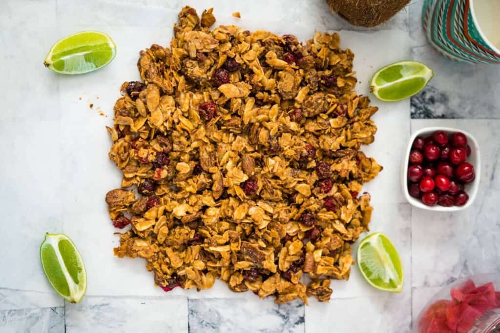 granola with cranberries and lime on a piece of parchment paper