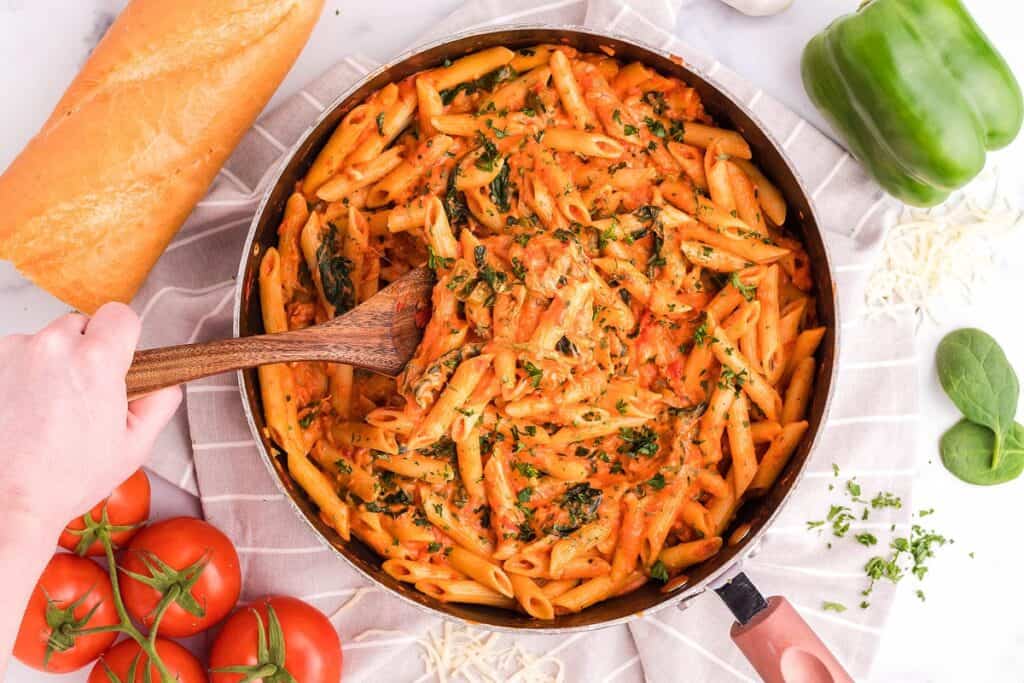 Overhead view of penne pasta with a rosa sauce in a pan.