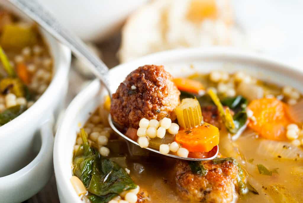 Italian Meatball Soup with parmesan cheese in white bowl