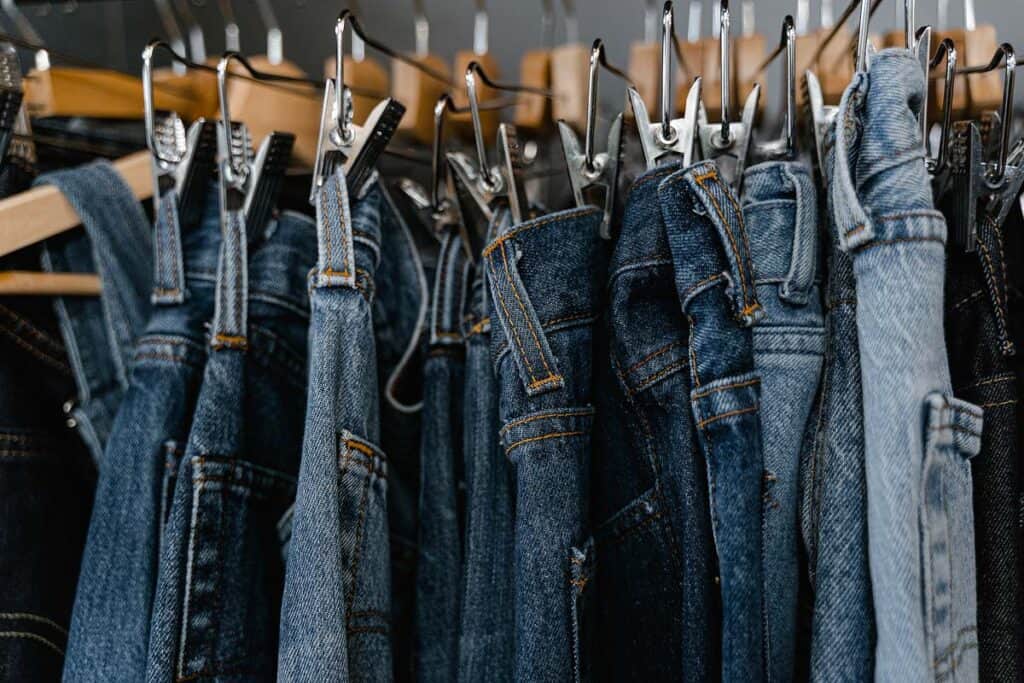 A rack of secondhand denim jeans at a thrift store.