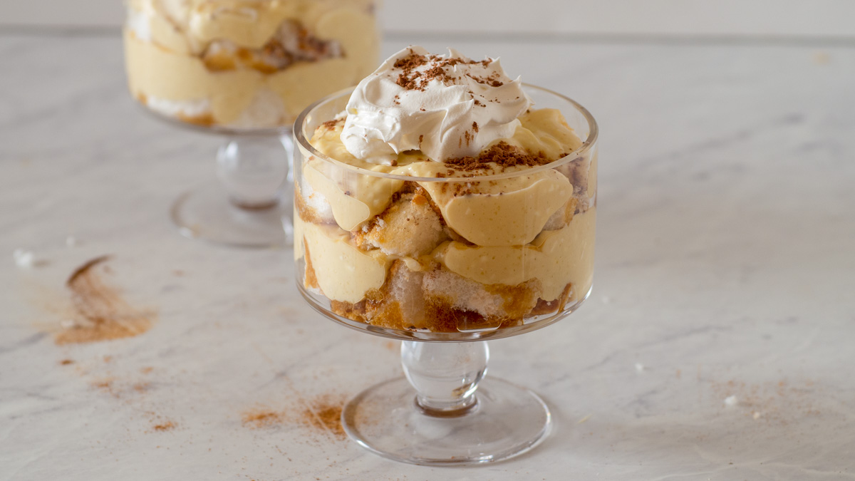 Layers of cake, coffee pudding and whipped cream in a trifle glass.