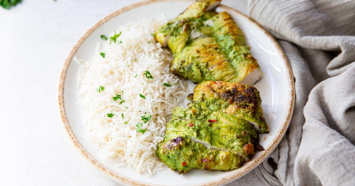 Trader Joe's Pesto Chicken in the Air Fryer on a white plate with white rice and parsley.