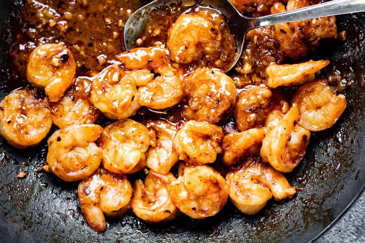 Low angle shot of szechuan shrimp in a wok.