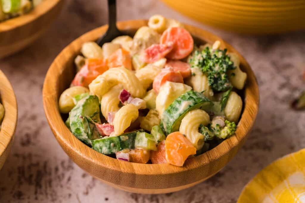 A vegetable pasta salad in a wood serving bowl. 