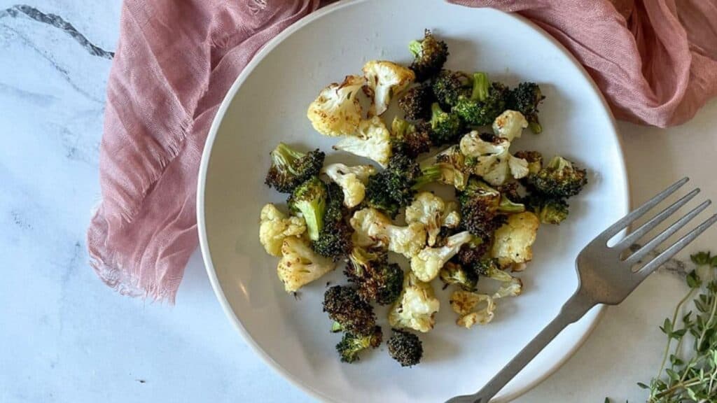 Air fryer broccoli and cauliflower on a white plate.