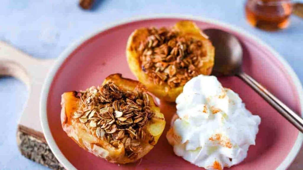 Air Fryer Baked Apples on a pink plate with whipped cream.