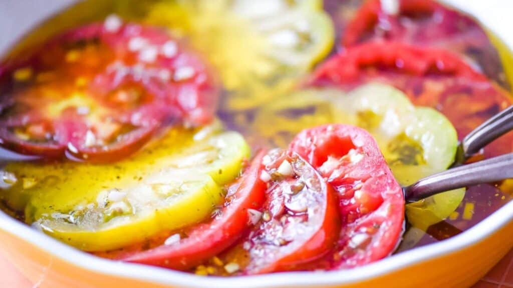 Marinated tomatoes in a yellow pie dish.