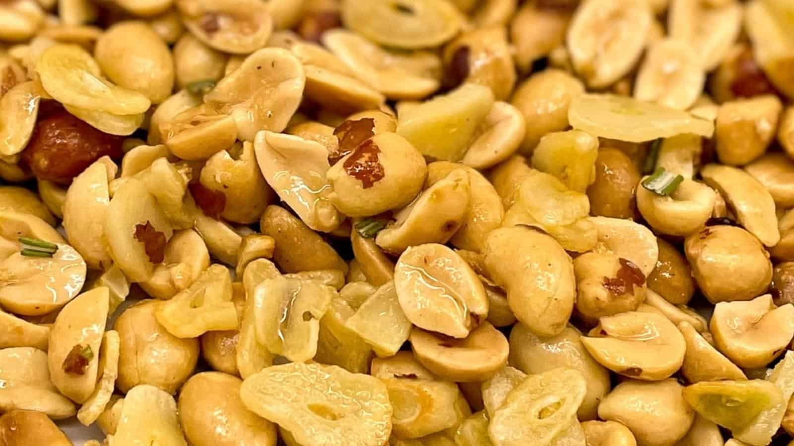Close-up shot of garlic peanuts with chopped rosemary.