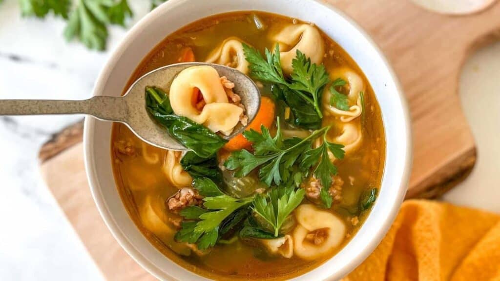 Instant pot tortellini soup in a white bowl.