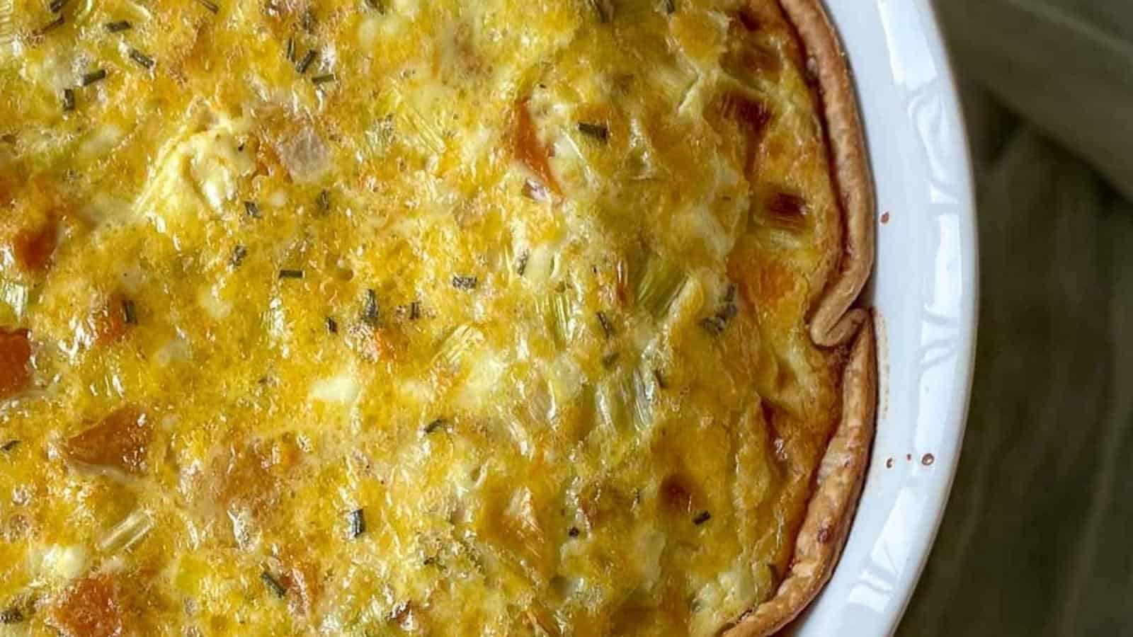 Closeup of leek and squash quiche with a green linen.