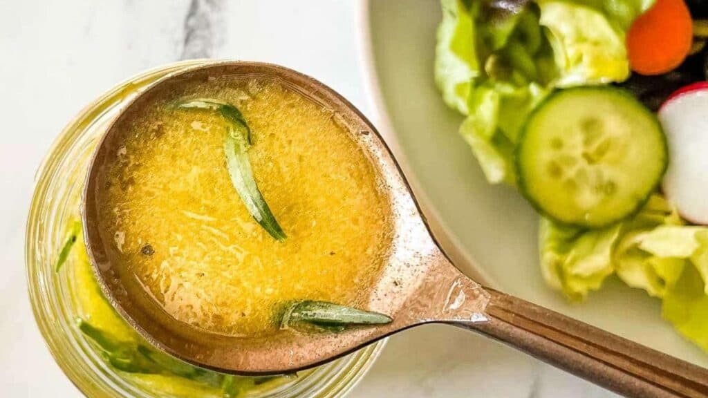 Closeup of lemon herb vinaigrette in a copper spoon.