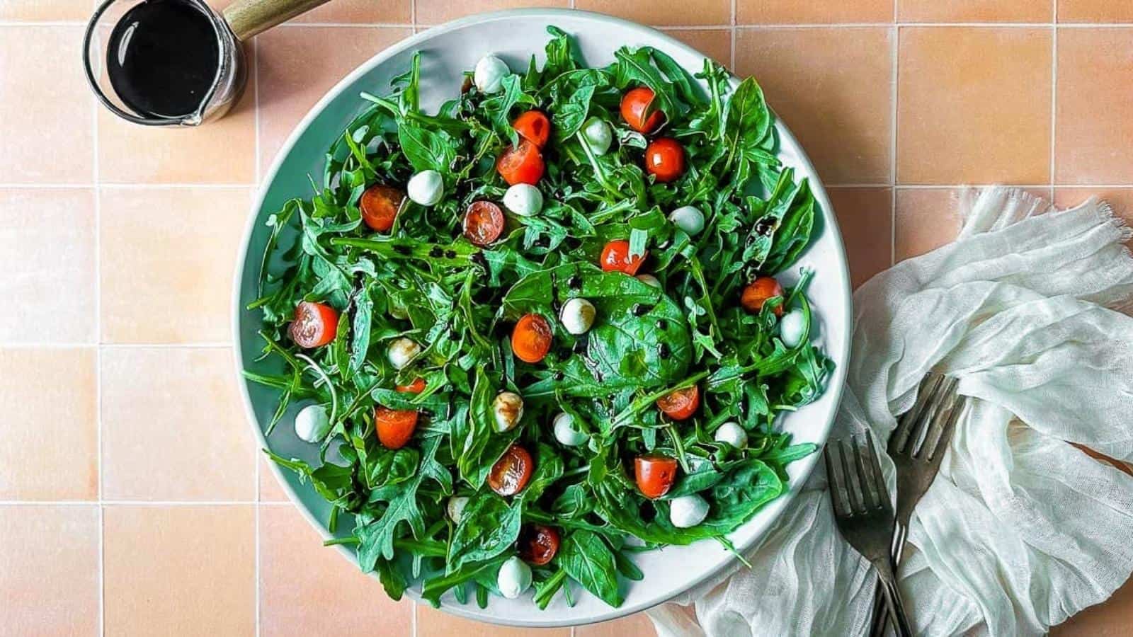 Arugula caprese salad on a white plate.