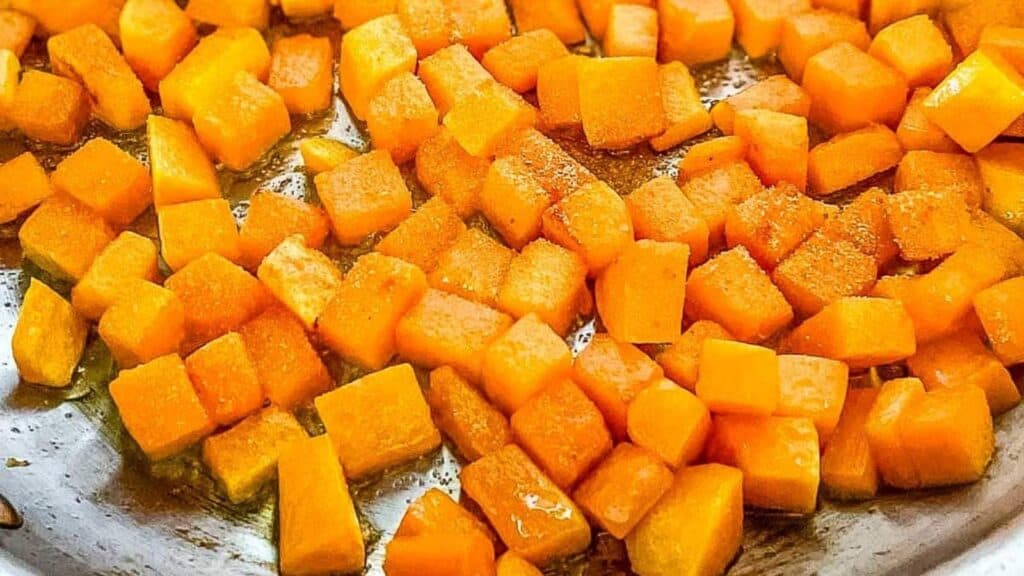 Sauteed butternut squash in a stainless steel pan.