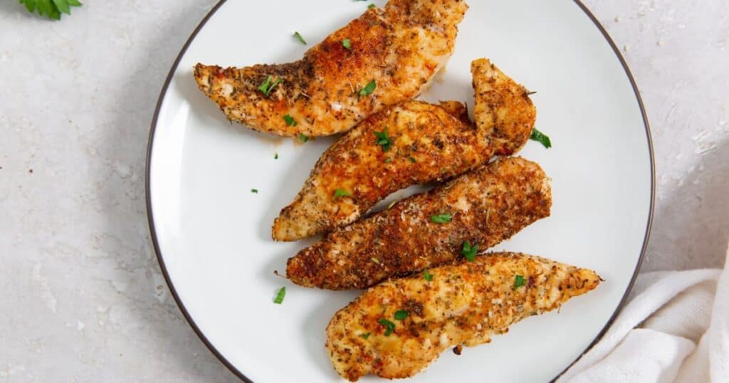 air fryer blackened chicken tenders on a white plate.