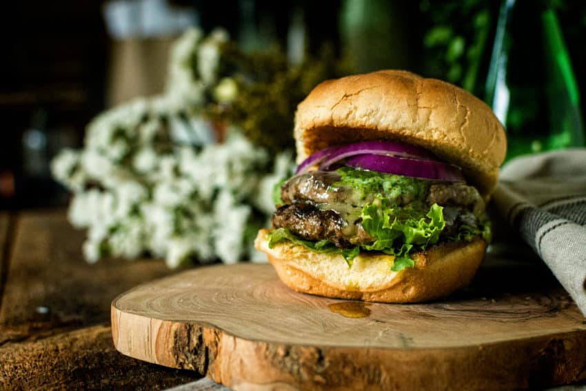 Glistening butter burger with chimichurri.