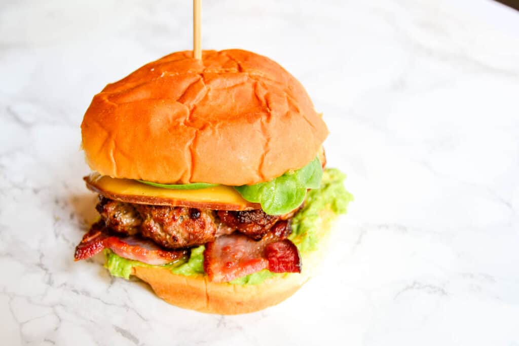 All- beef bacon avocado burger on a marble background.