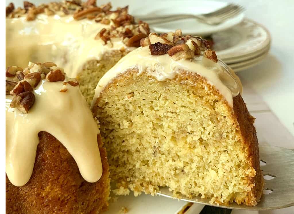 Iced banana cake with pecans on top.