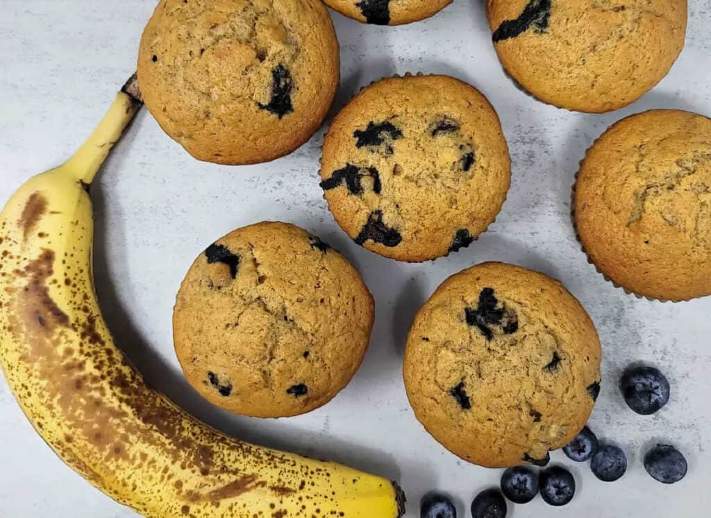 Banana blueberry muffins with an overripe banana and fresh blueberries.