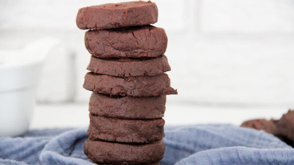 A stack of chocolate short bread cookies on a blue towel.