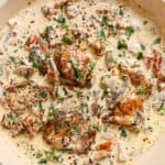 Chicken with creamy mushroom sauce in a pan.