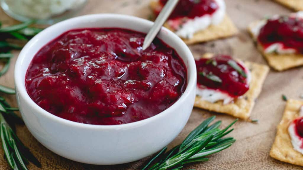 Chinese 5 spice plum jam in a white bowl with a small spoon.