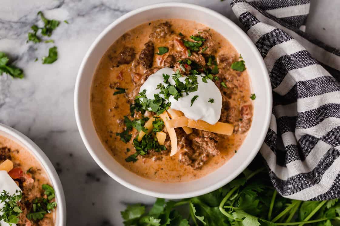 A bowl of crock pot taco soup topped with sour cream and cilantro.