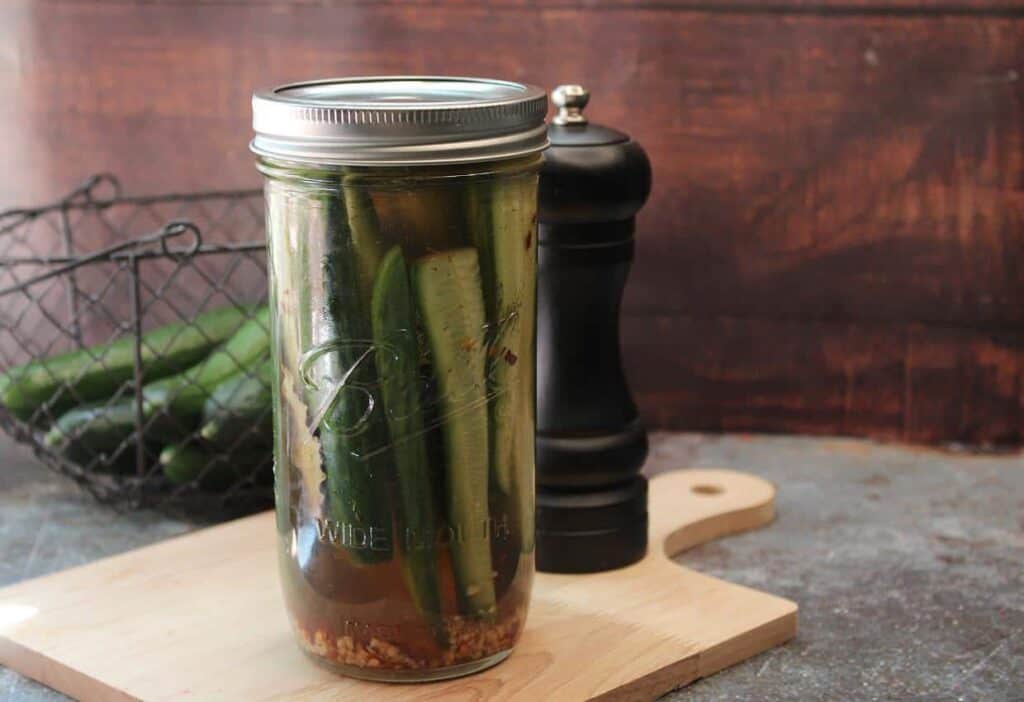 Jar of dill pickle spears with an other jar in the background.
