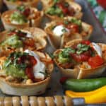 Mini chicken taco cups on a silver tray.