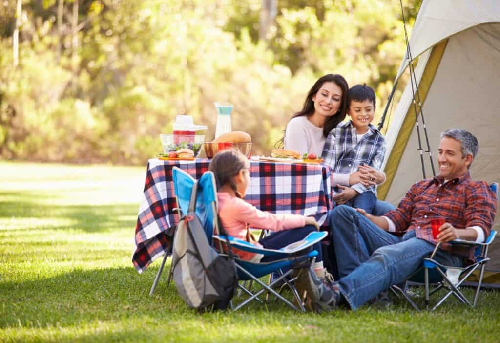 Family resting by tent.
