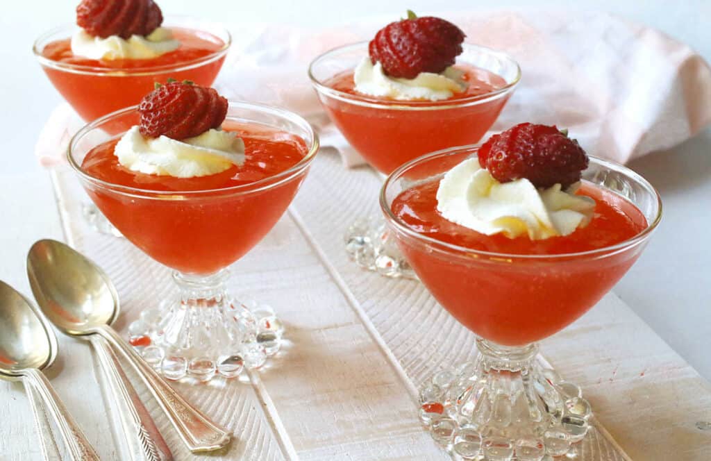 Strawberry gelatin dessert in glass dessert dishes.