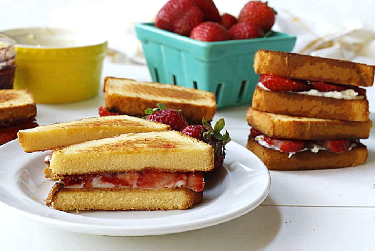 A white plate with a strawberry grilled cheese sandwich.