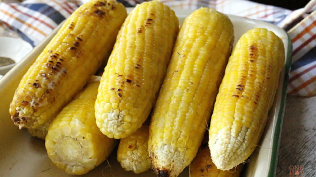 A pan filled with ears of grilled corn.