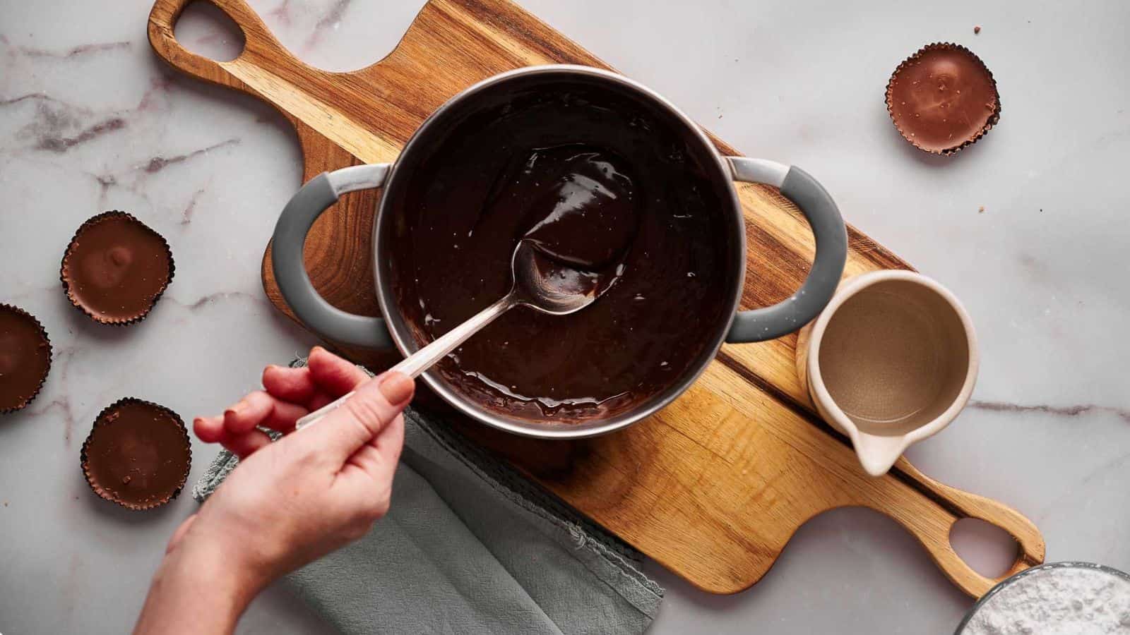 Hot fudge sauce being stirred in a pan.
