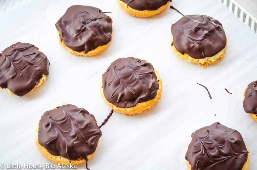 Chocolate covered jaffa cakes on parchement paper on a baking sheet. 