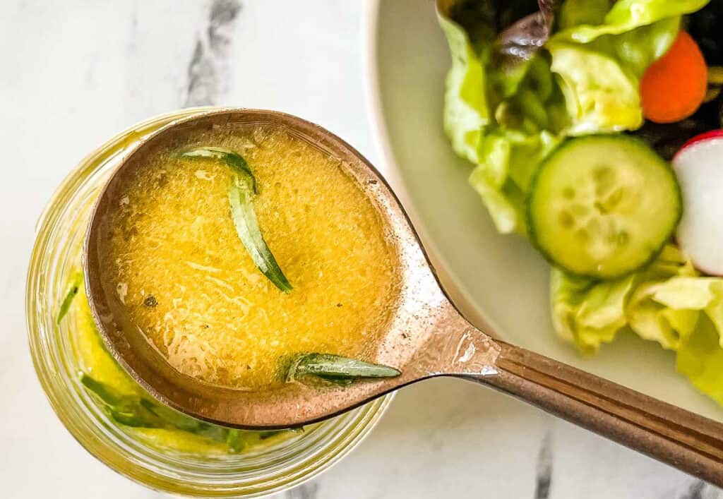 Lemon herb vinaigrette in a copper-colored spoon.