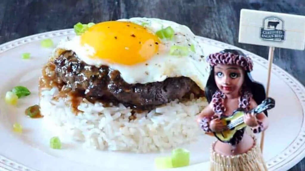 plate of rice topped with patty and egg.