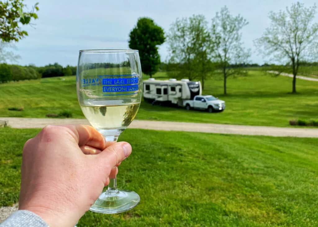 Wine glass with an RV and truck in the background.